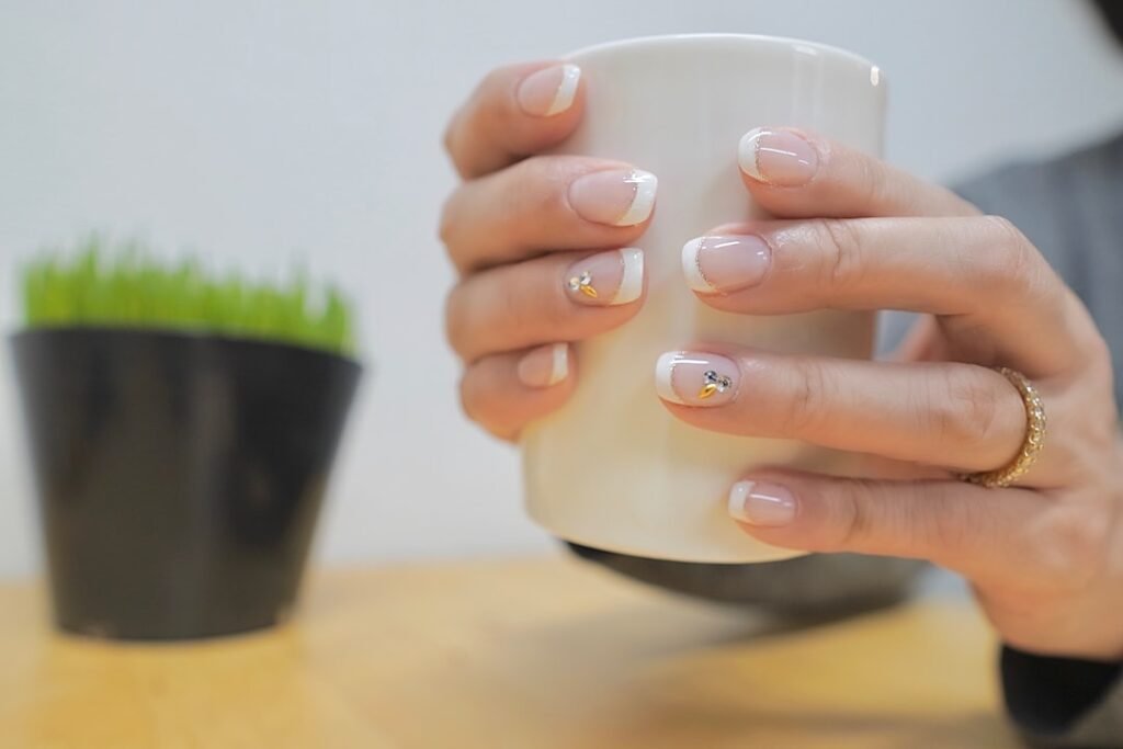A lady with polished nails holding a cup
